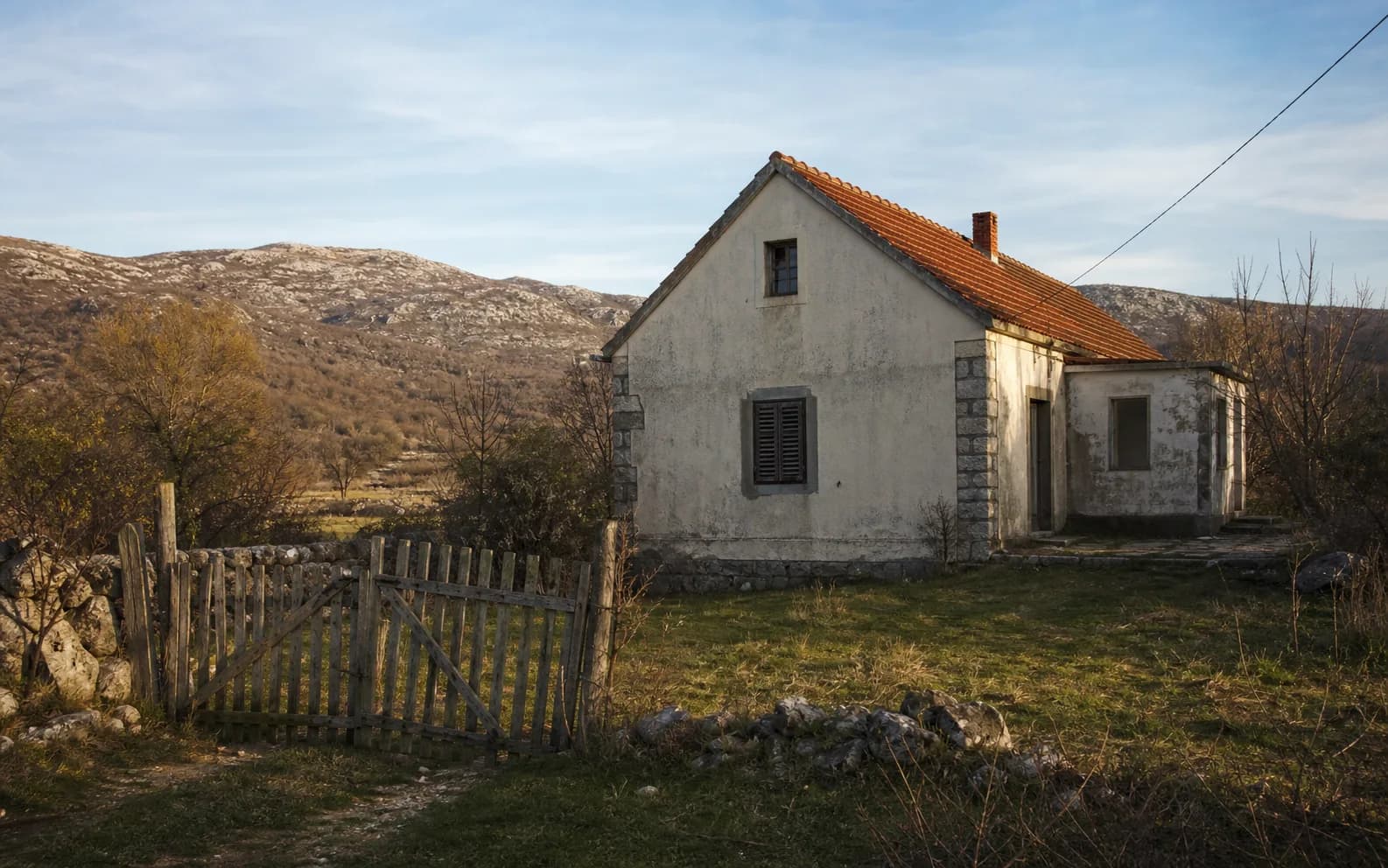 Ilustrativna fotografija za Begluci, Gračac: stambeni eksterijer uklopljen u otvoreni krajolik.