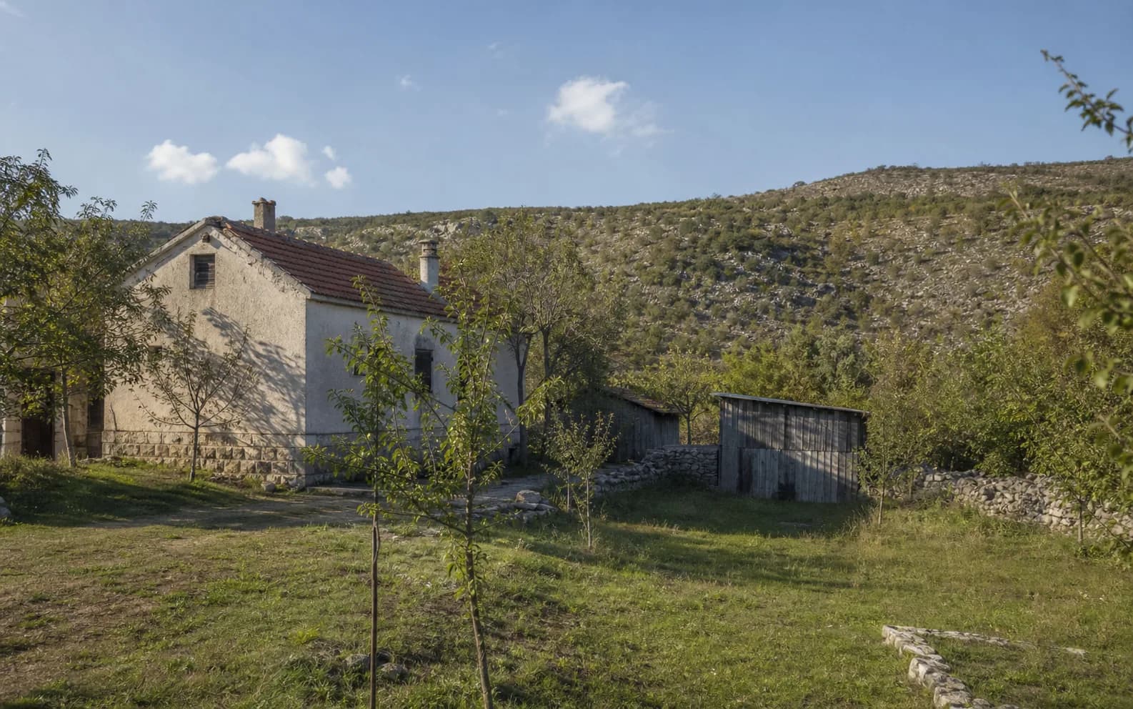 Ilustrativna fotografija za Brotnja, Gračac: stambeni eksterijer uklopljen u otvoreni krajolik.