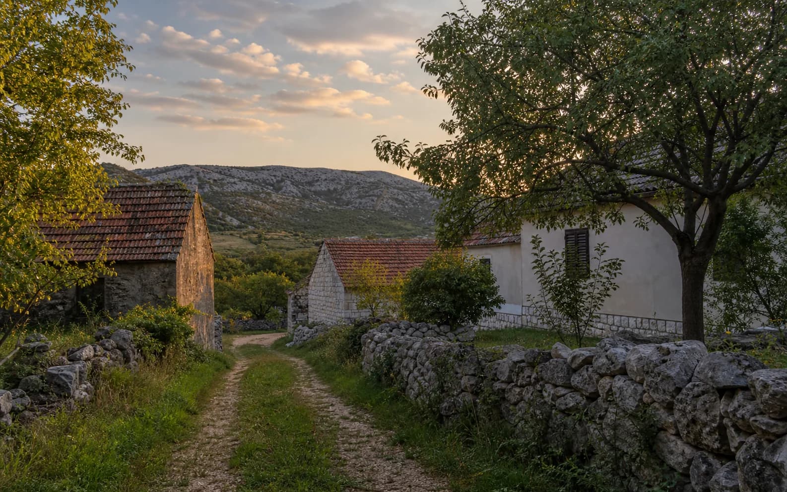 Ilustrativna fotografija za Kom, Gračac: mirna ulica naselja u brdskom okruženju.