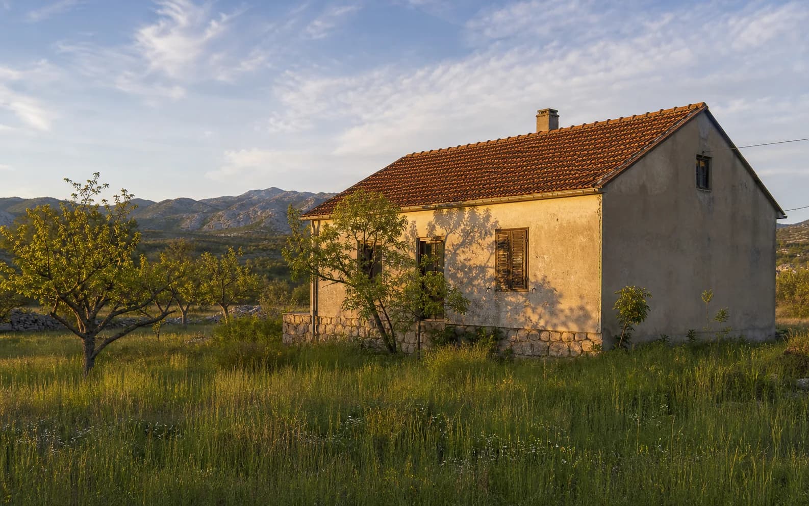 Illustrative photo for Kunovac Kupirovački, Gračac: a residential exterior set within an open landscape.