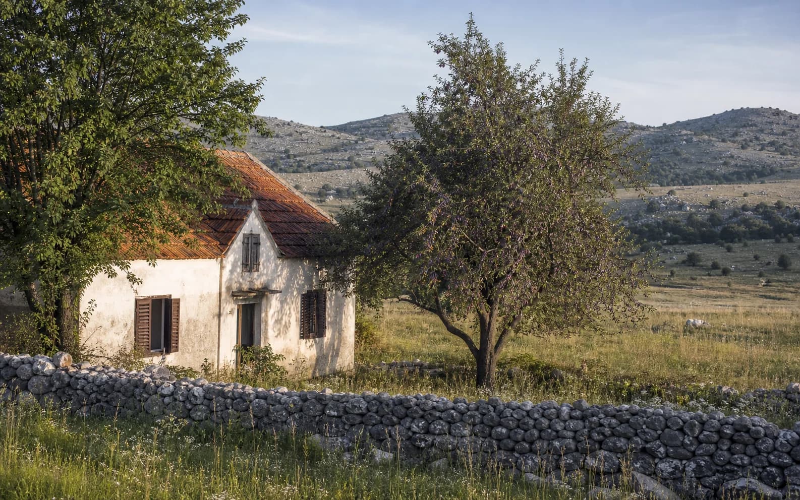 Ilustrativna fotografija za Otrić, Gračac: stambeni eksterijer uklopljen u otvoreni krajolik.