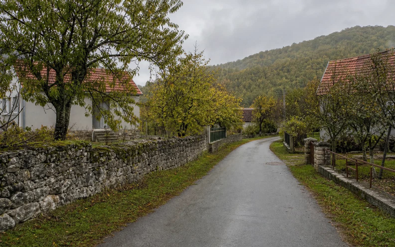 Ilustrativna fotografija za Pribudić, Gračac: mirna ulica naselja u brdskom okruženju.