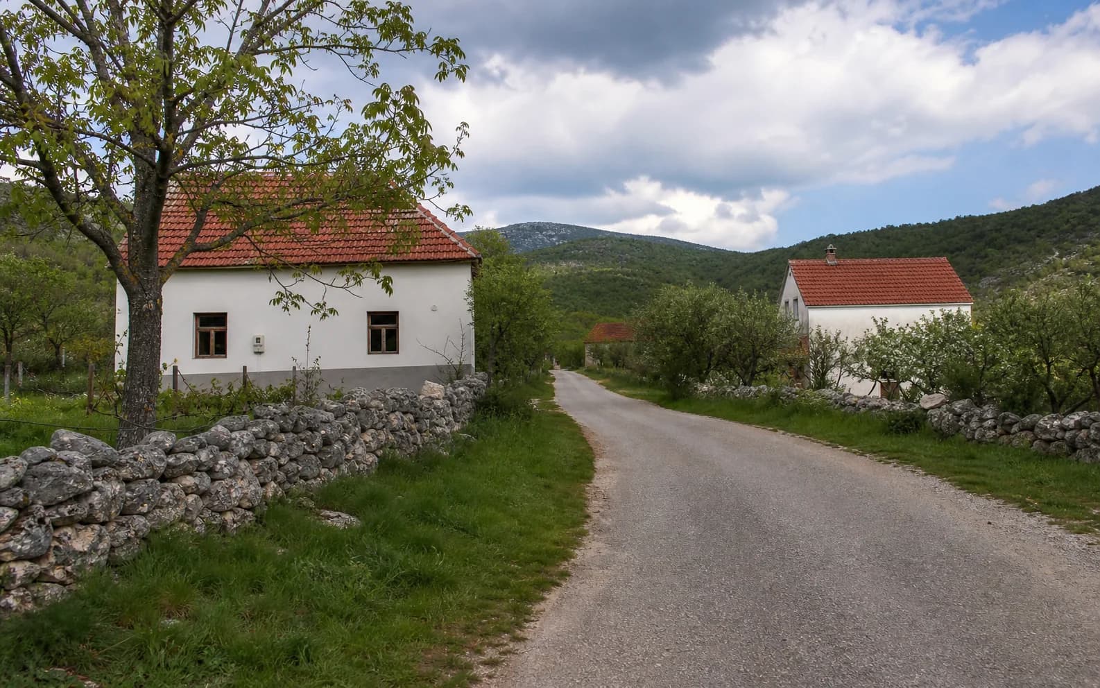 Ilustrativna fotografija za Zrmanja, Gračac: mirna ulica naselja u brdskom okruženju.