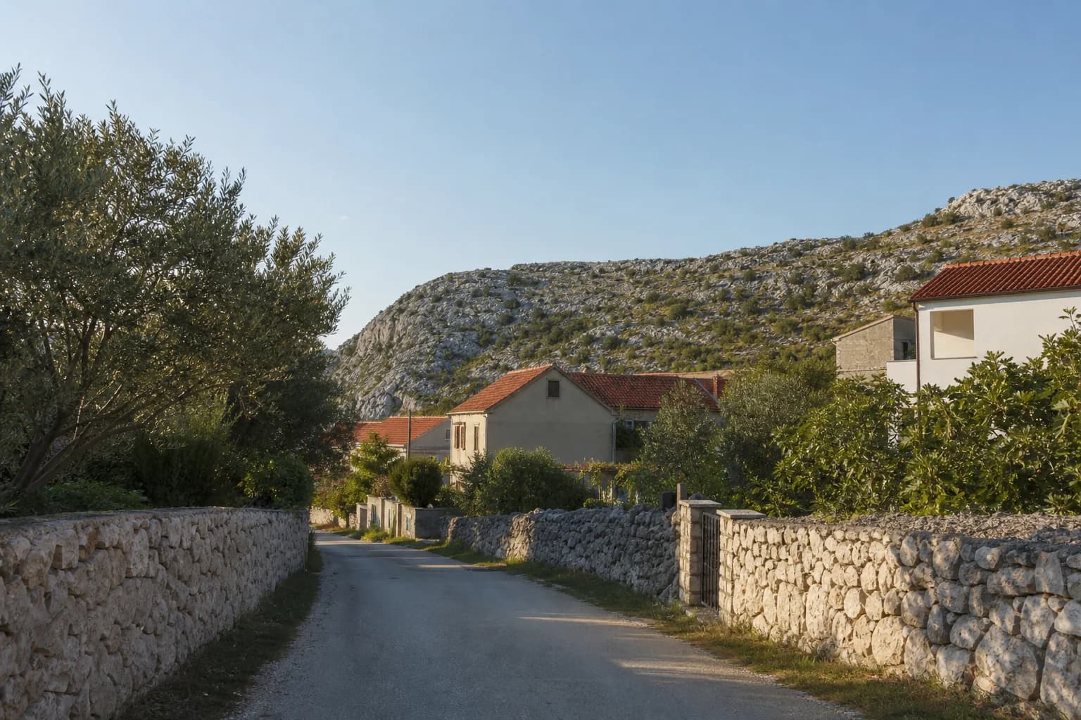 Illustratives Foto für Zaton Obrovački, Jasenice: ruhige Straße in felsiger Küstenlandschaft.