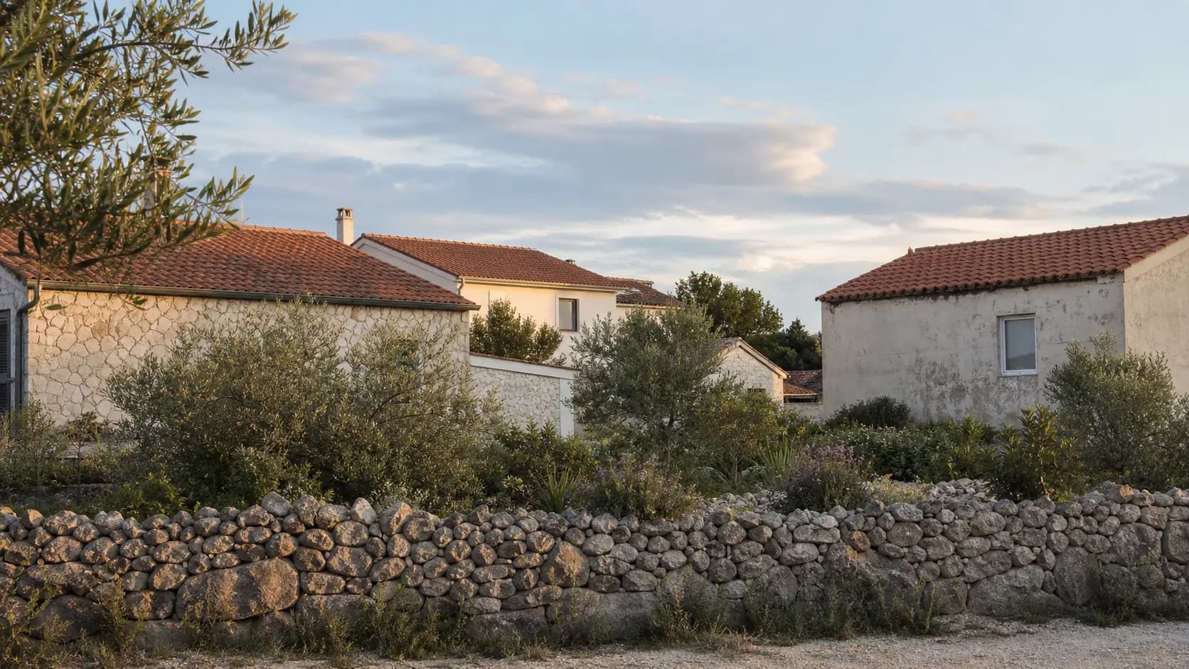 Suhozid, mediteranski vrt i niske obalne kuće u ilustrativnom stambenom okruženju Mandri.