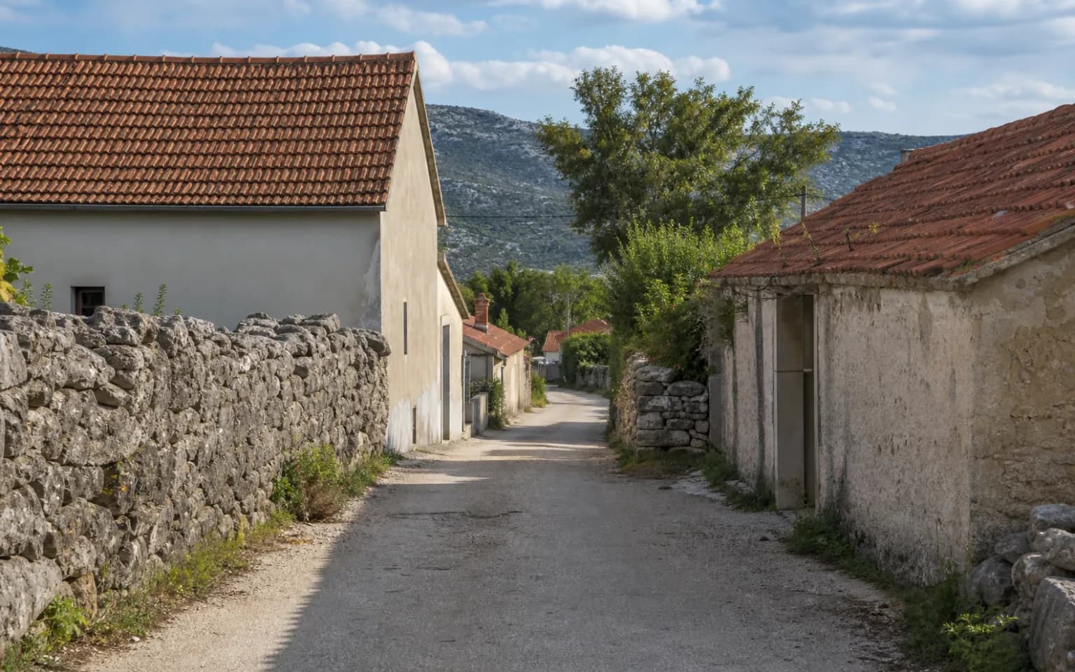 KI-generierte illustrative ruhige Dorfstraße mit Steinmauern, einfachen Häusern und Karsthügel im Ambiente von Gornji Karin.