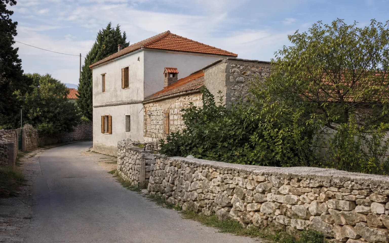 AI-generated illustrative exterior of a modest Dalmatian home with stonework, shutters and natural greenery in the Kaštel Žegarski setting.