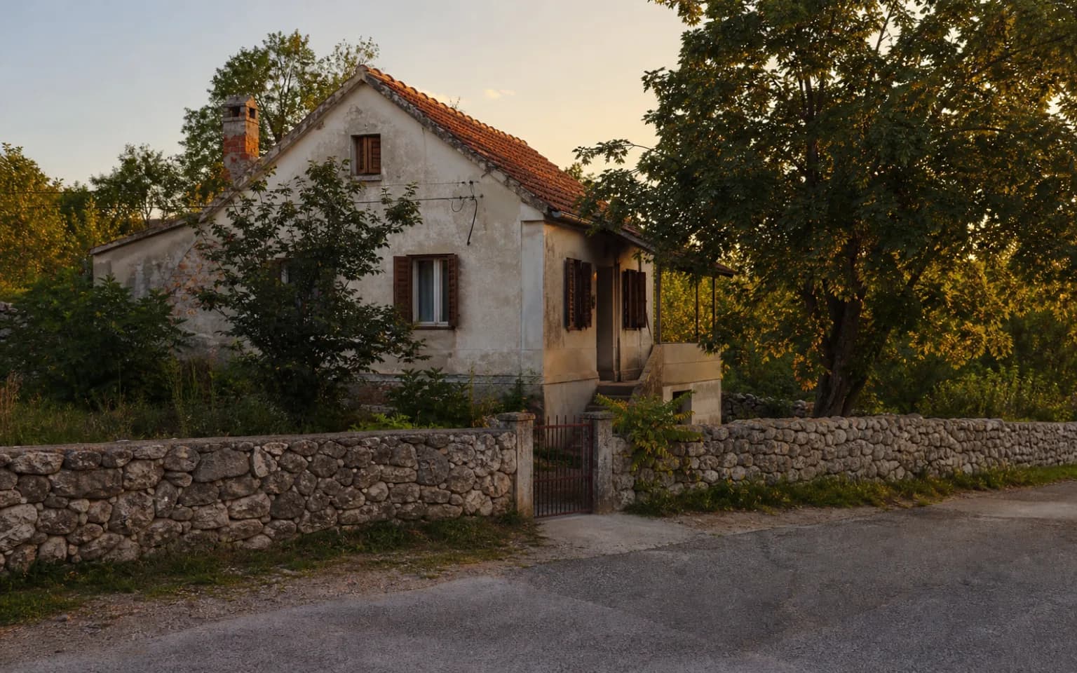 AI-generated illustrative exterior of a modest Dalmatian home with a stone wall, shutters and mature greenery in the Muškovci setting.