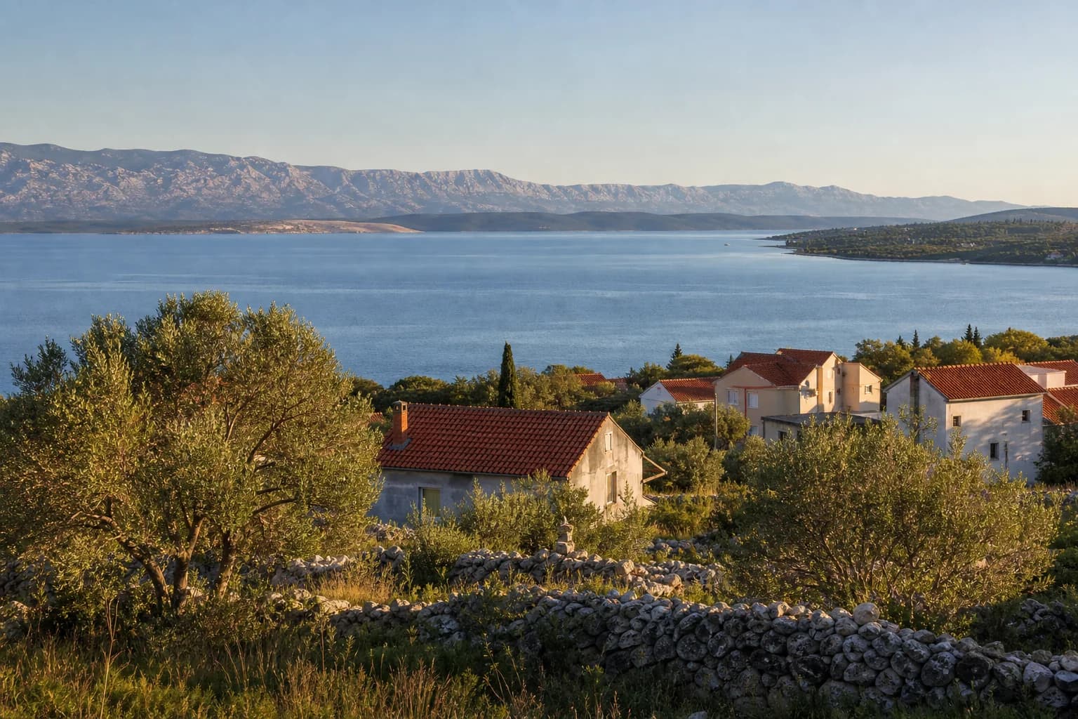 AI ilustrativni široki pogled na mirnu obalu, masline, kuće i planinski horizont u ambijentu Krneze kod Ražanca.