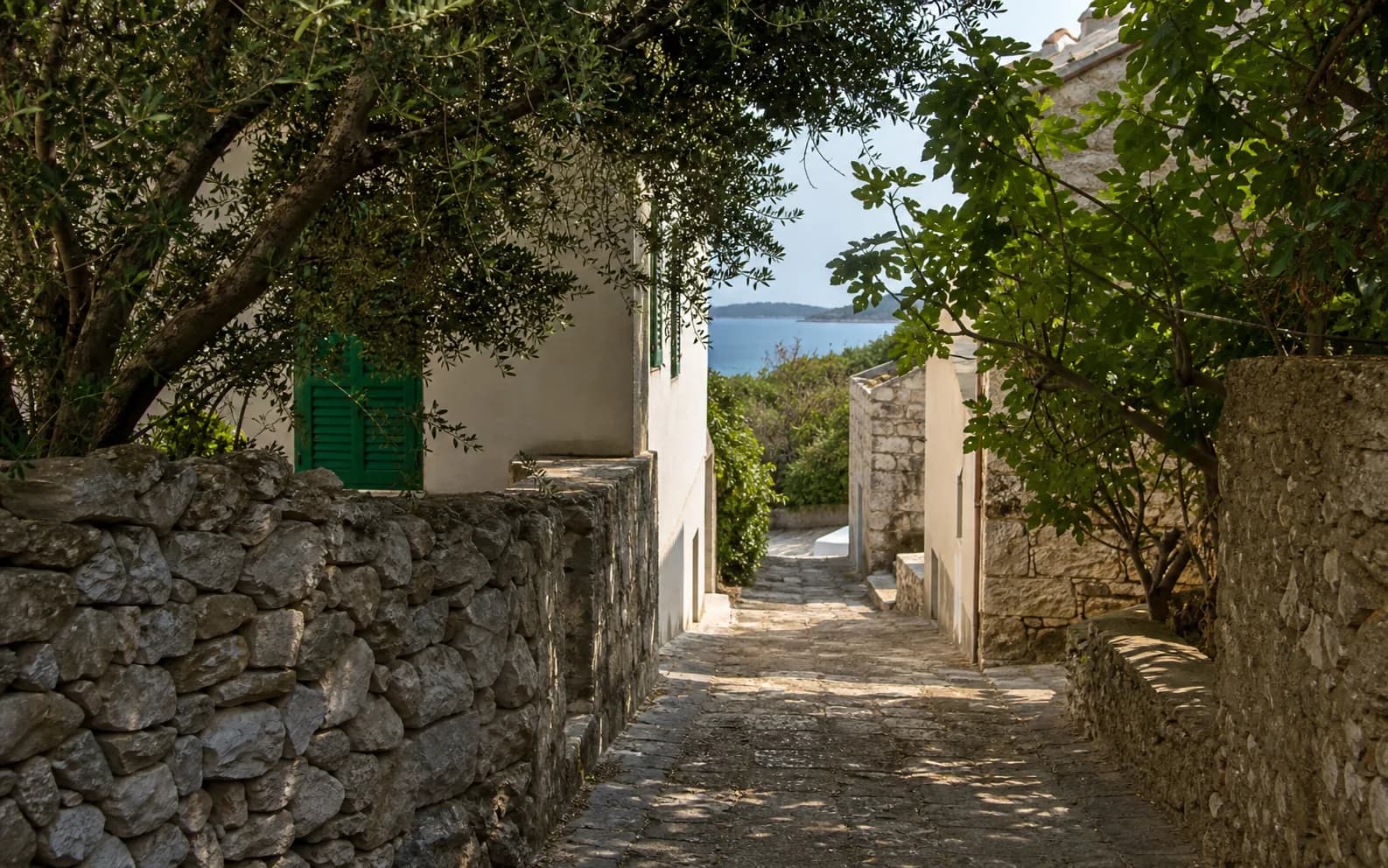 Ilustrativna fotografija za Rava, Zadar: mirna ulica među kamenim kućama.
