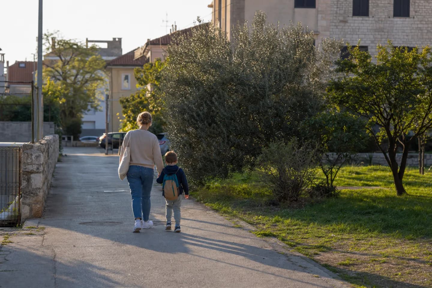 Odrasla osoba i dijete na kasnopopodnevnoj pješačkoj ruti u stambenom dijelu Zadra.
