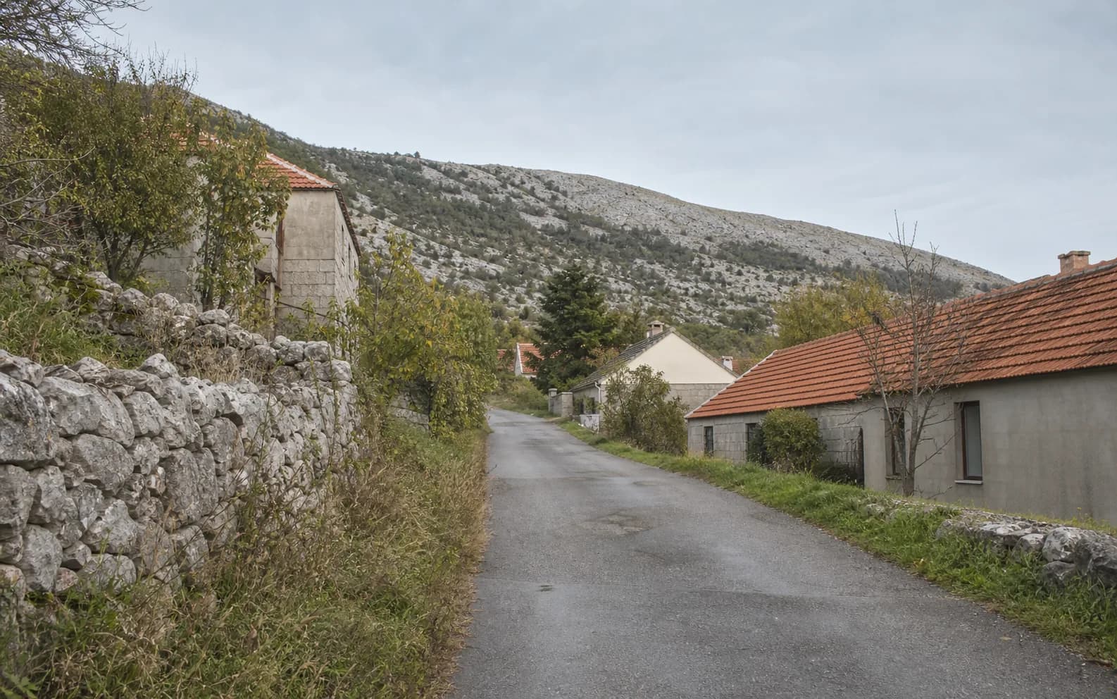 Ilustrativna fotografija za Bruvno, Gračac: mirna ulica naselja u brdskom okruženju.