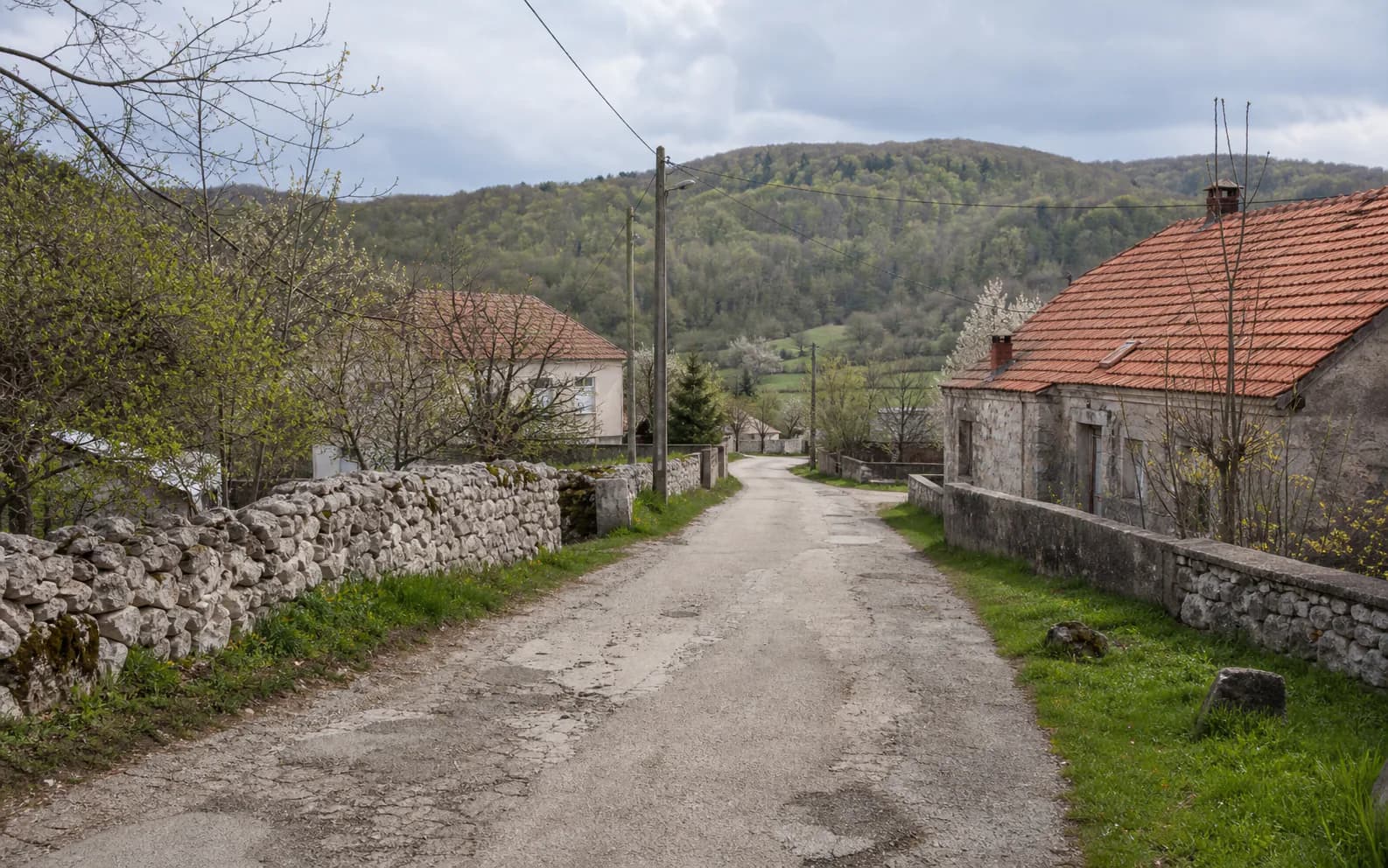 Ilustrativna fotografija za Cerovac, Gračac: mirna ulica naselja u brdskom okruženju.