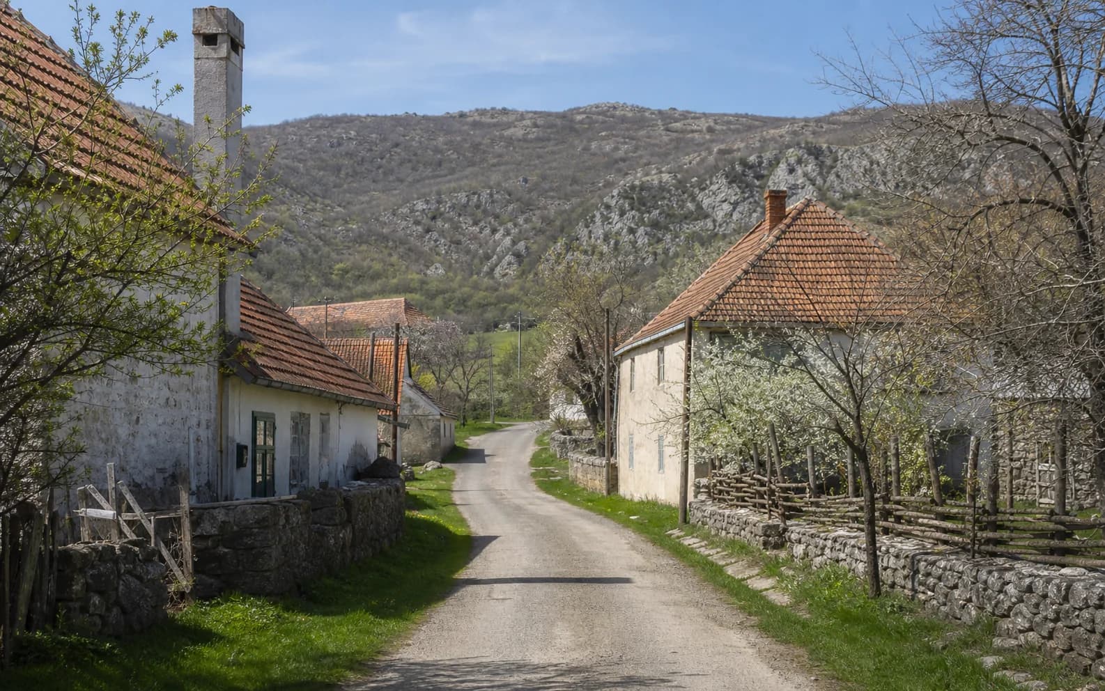 Illustrative photo for Glogovo, Gračac: a quiet settlement street in a hilly setting.