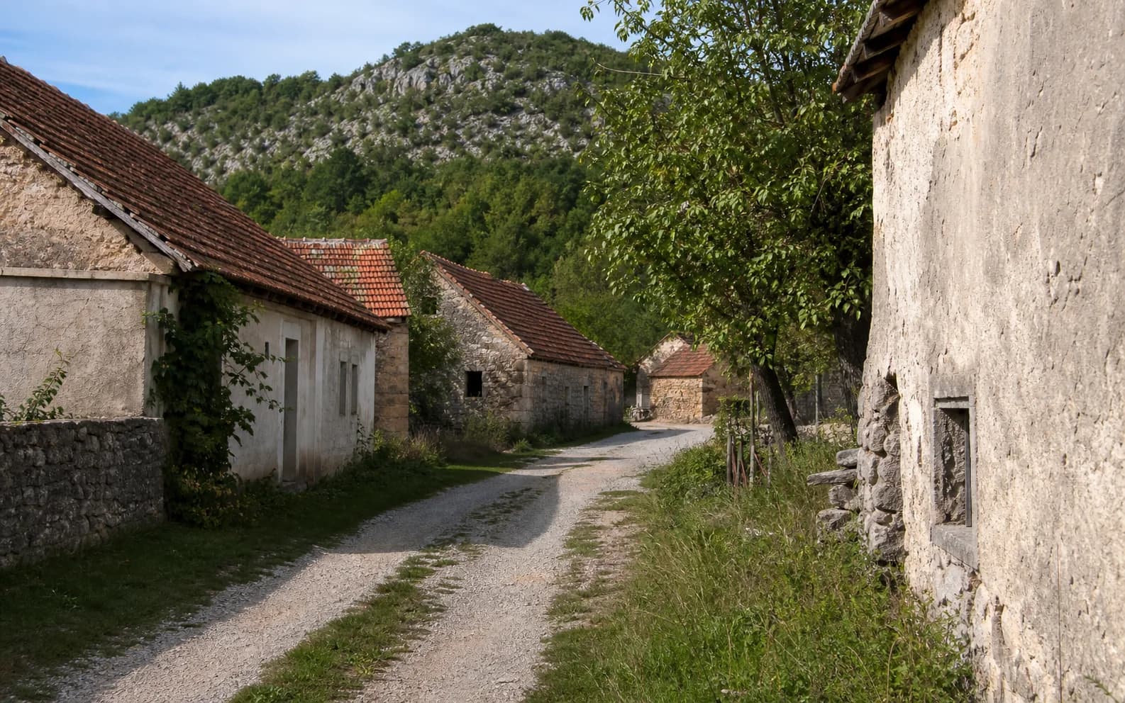 Ilustrativna fotografija za Mazin, Gračac: mirna ulica naselja u brdskom okruženju.