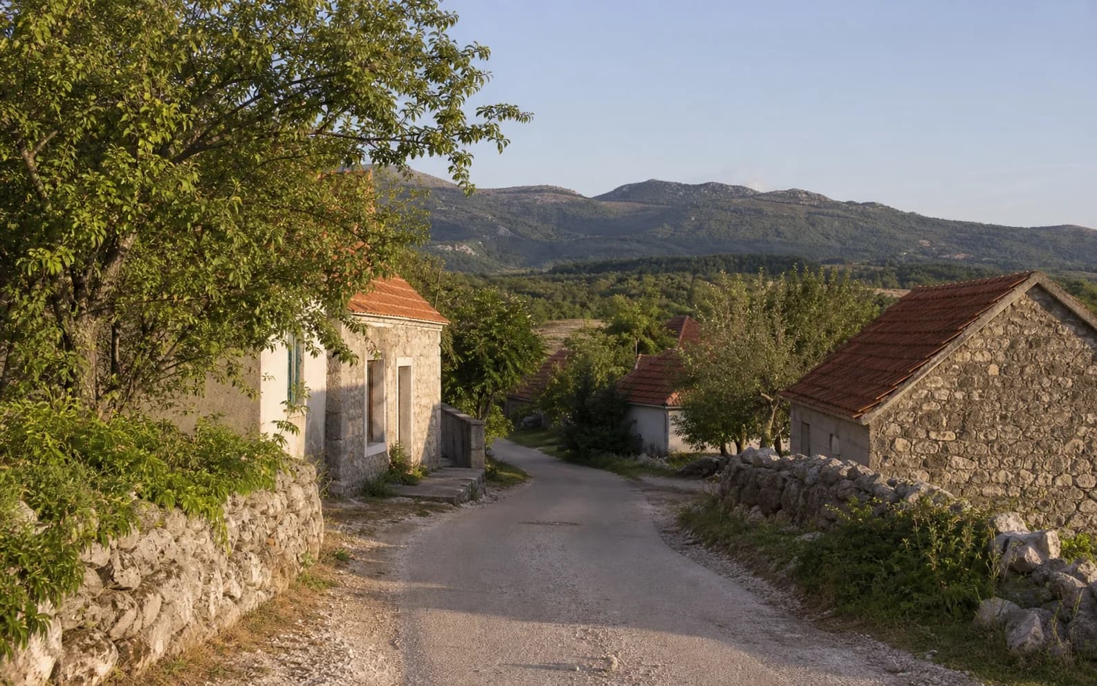 Ilustrativna fotografija za Nadvrelo, Gračac: mirna ulica naselja u brdskom okruženju.