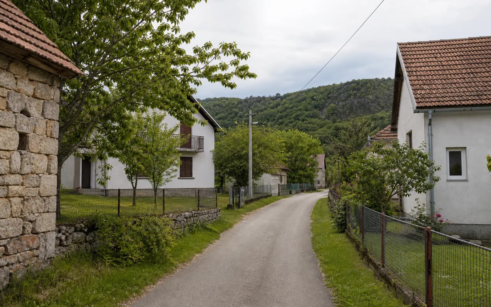 Illustrative photo for Omsica, Gračac: a quiet settlement street in a hilly setting.