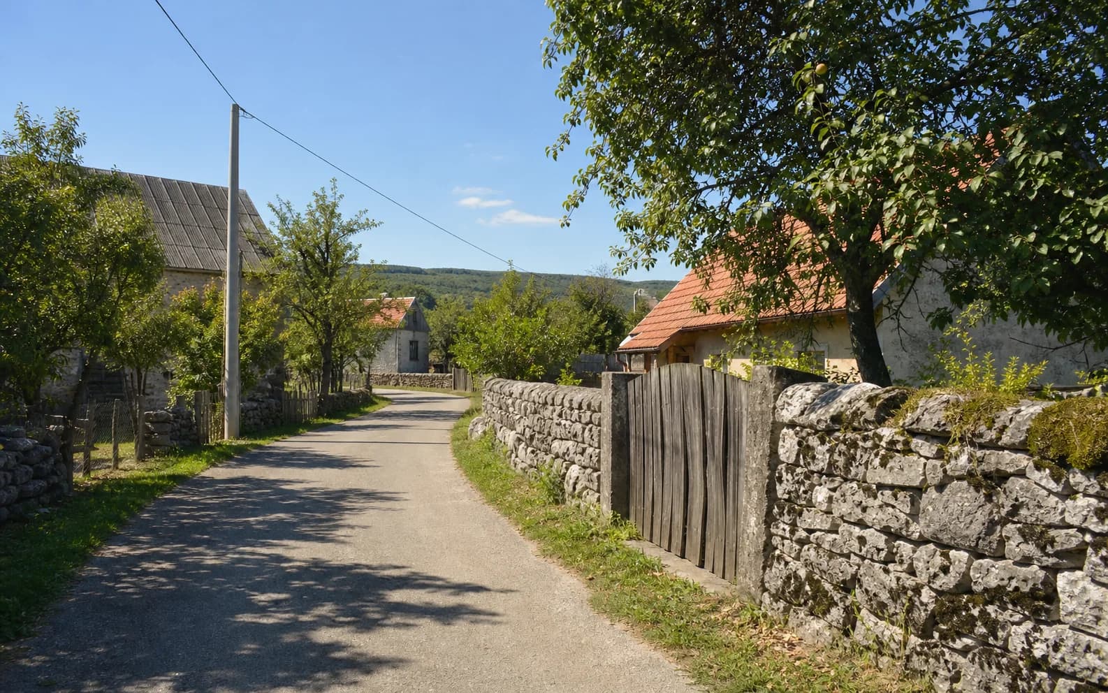 Ilustrativna fotografija za Rastičevo, Gračac: mirna ulica naselja u brdskom okruženju.
