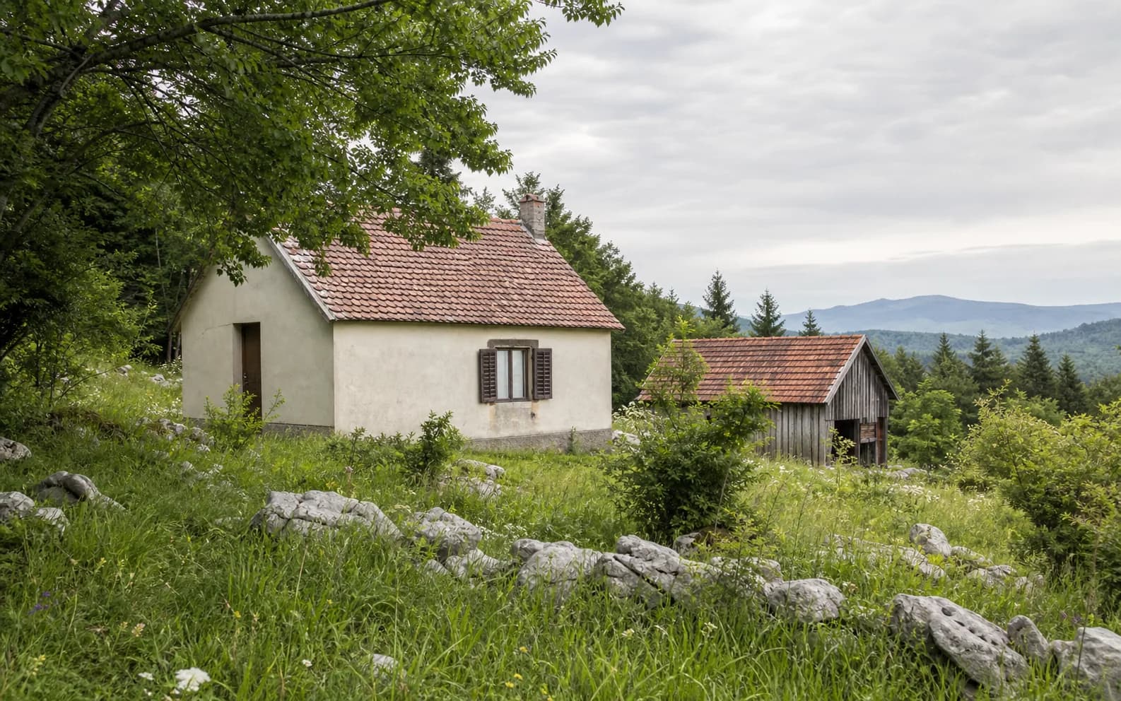 Ilustrativna fotografija za Tiškovac Lički, Gračac: stambeni eksterijer uklopljen u otvoreni krajolik.
