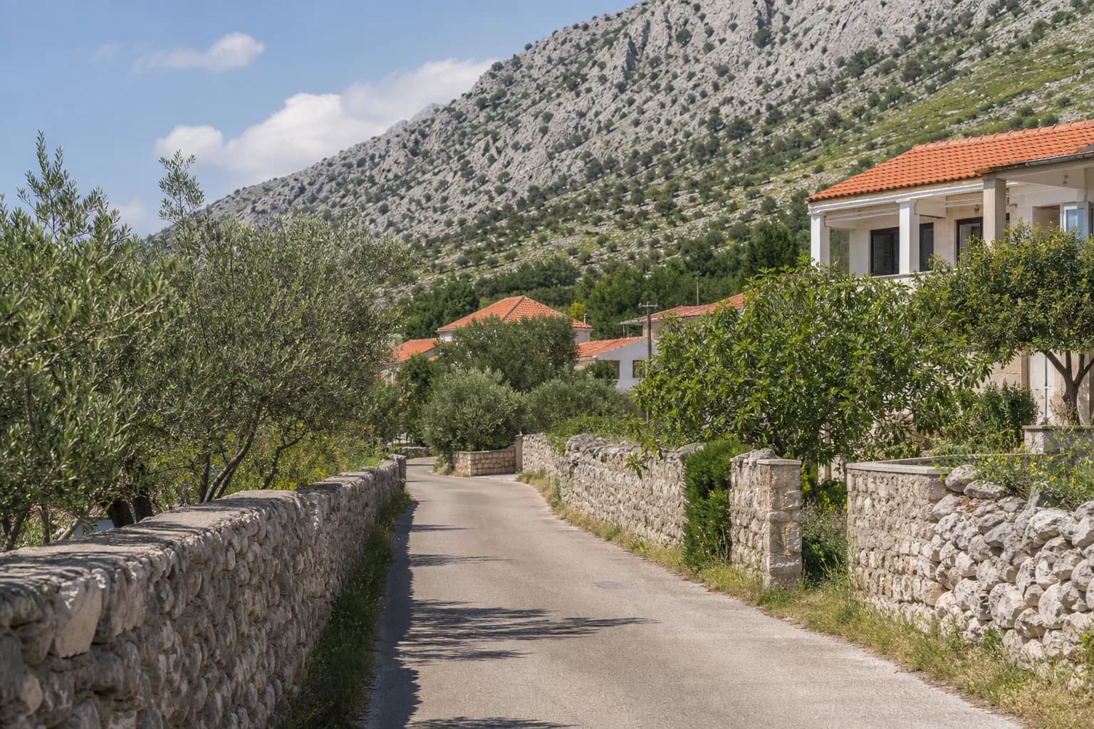 Ilustrativna fotografija za Rovanjska, Jasenice: mirna ulica u kamenitom obalnom krajoliku.