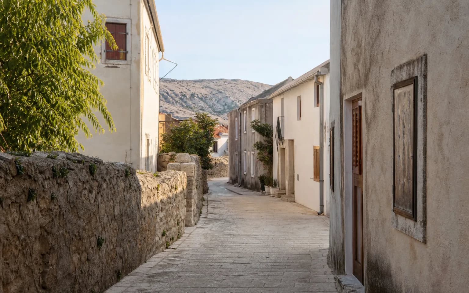 AI-generated illustrative quiet stone lane with simple facades and Mediterranean greenery in the Bošana setting.