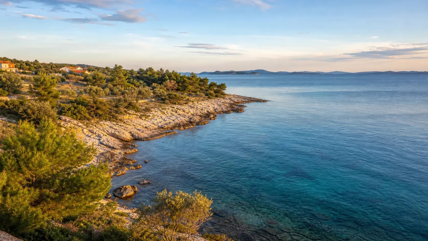 Ilustrativni široki pogled na kamenitu obalu, borove, masline i more — Neviđane, Pašman.